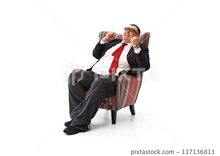 Success. Fat businessman, employee in formal wear sitting in armchair and expressing positive emotions of achievements isolated on white background. Success. Fat businessman, employee in formal wear sitting in armchair and expressing positive emotions of achievements isolated on white background. 117136813