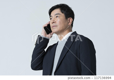 A man in his 50s making a phone call A man in his 50s making a phone call 117136994