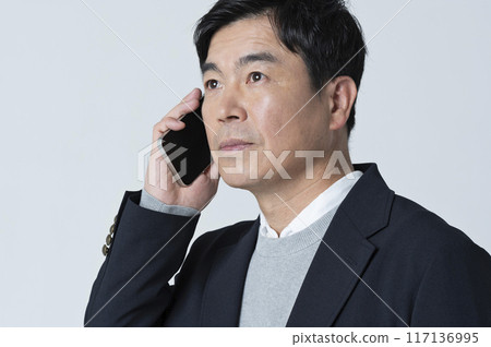 A man in his 50s making a phone call 117136995