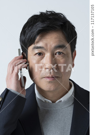 A man in his 50s making a phone call 117137105