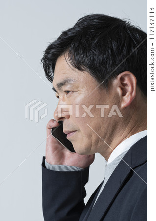 A man in his 50s receives negative news over the phone A man in his 50s receives negative news over the phone 117137113