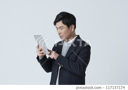 A man in his 50s using a tablet A man in his 50s using a tablet 117137174