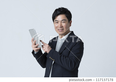 A man in his 50s using a tablet A man in his 50s using a tablet 117137178