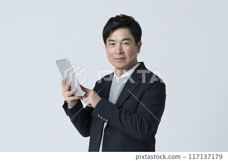 A man in his 50s using a tablet A man in his 50s using a tablet 117137179
