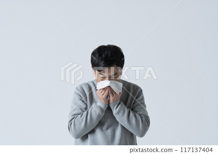 A man in his 50s blowing his nose A man in his 50s blowing his nose 117137404