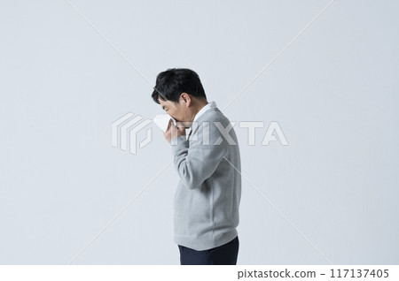 A man in his 50s blowing his nose 117137405