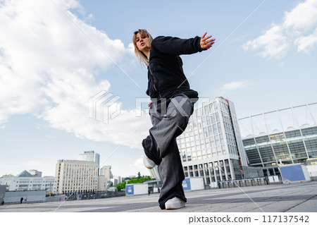 Young Dancer Performing Dynamic Moves in Urban Setting Under Clear Sky Young Dancer Performing Dynamic Moves in Urban Setting Under Clear Sky 117137542