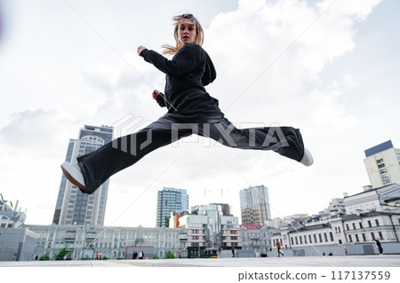 Dynamic Urban Dance Performance By a Young Woman in a City Square During Daylight Dynamic Urban Dance Performance By a Young Woman in a City Square During Daylight 117137559