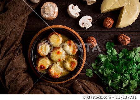 Traditional Georgian dish, appetizer, stuffed mushrooms, Sulguni cheese, baked in a Ketzi clay pan, on a wooden table, close-up, no people, 117137731