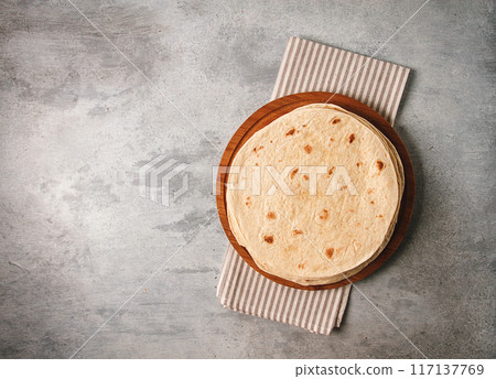 A stack of Mexican tortillas, on a gray table, top view, close-up, no people, 117137769