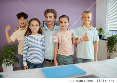 Group of Children and Teacher Smiling in Classroom Group of Children and Teacher Smiling in Classroom 117138725
