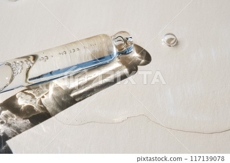 Pipette with serum on a beige background. 117139078