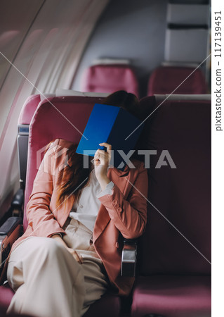 Tired asian woman with headache feeling sick while sitting in the airplane , Passengers near the window. 117139451