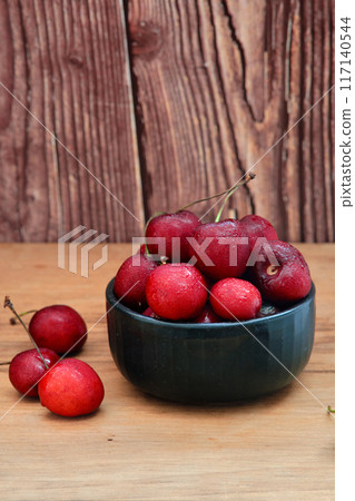 ripe cherries on a dark wooden background 117140544