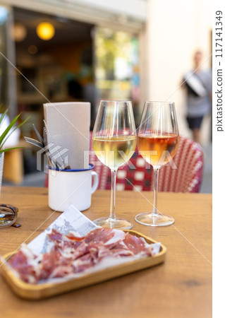 Served table set at summer terrace cafe. Romantic table for two person. Two Glasses with wine on table in a restaurant, alcohol luxury background. Served table set at summer terrace cafe. Romantic table for two person. Two Glasses with wine on table in a restaurant, alcohol luxury background. 117141349