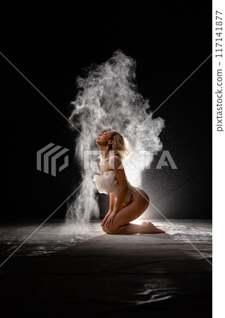 Young slim woman with spread flour on the air Young slim woman with spread flour on the air 117141877