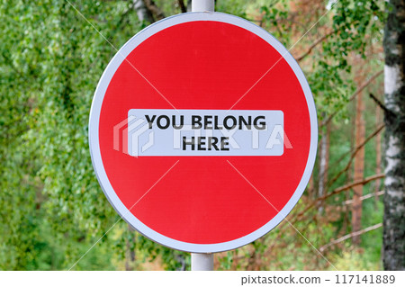 Diversity, inclusion, belonging and you belong here concept. YOU BELONG HERE on the sign that traffic is prohibited against the background of the forest 117141889
