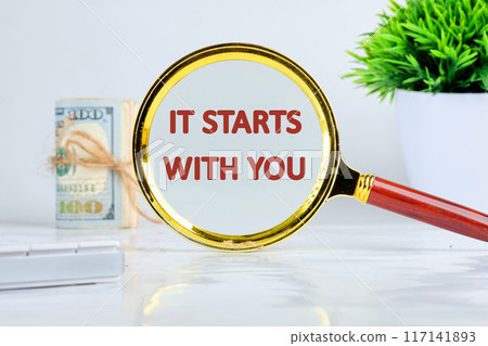 Conceptual it starts with you symbol. Copy space. It starts with you words written a conceptual phrase through a magnifying glass on a gray background Conceptual it starts with you symbol. Copy space. It starts with you words written a conceptual phrase through a magnifying glass on a gray background 117141893