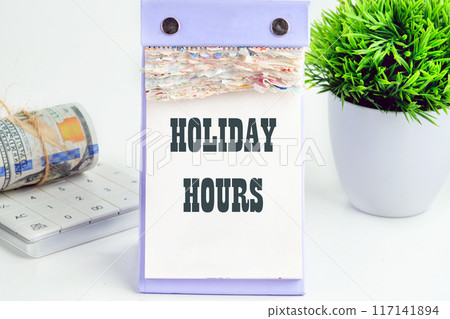 Holiday periods, text concept word HOLIDAY HOURS a conceptual phrase on a desktop tear-off calendar Holiday periods, text concept word HOLIDAY HOURS a conceptual phrase on a desktop tear-off calendar 117141894