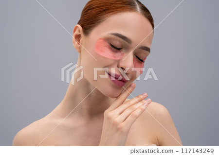 Relaxed young woman with moisturizing patches under her eyes 117143249