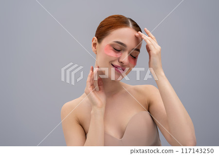 Relaxed young woman with moisturizing patches under her eyes Relaxed young woman with moisturizing patches under her eyes 117143250