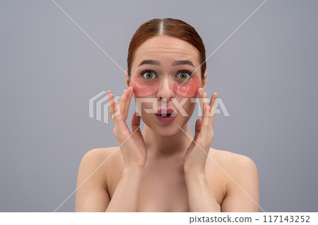 Relaxed young woman with moisturizing patches under her eyes Relaxed young woman with moisturizing patches under her eyes 117143252
