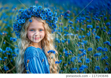 Girl in wreath from blue flowers. Field with cornflower summer background. Beautiful blond hair kid in blue crown. Young cute happy girl. Little child in flower meadow. Midsummer cornflower wreath 117143646