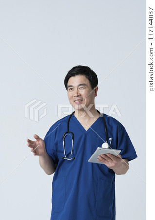 A medical worker in his 50s talking to a patient 117144037