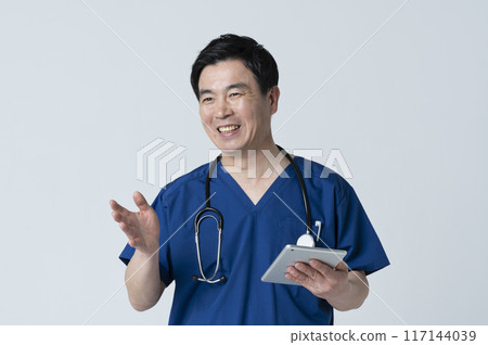 A medical worker in his 50s talking to a patient 117144039