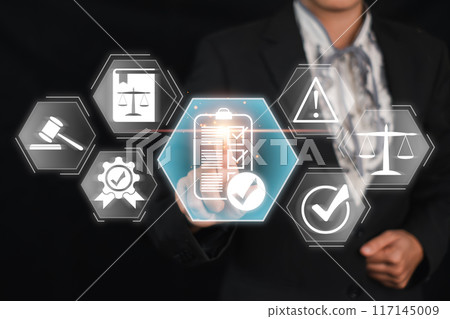 Businessman in a suit interacting with virtual icons representing compliance, legal regulations, and business standards. 117145009