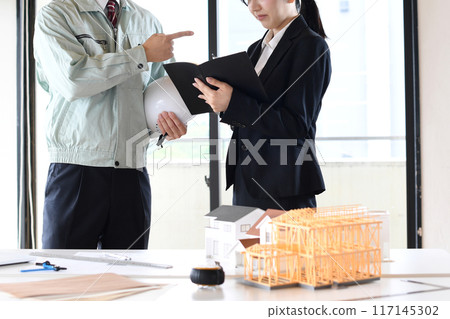男女辦公室職員在建築模型前爭論 男女辦公室職員在建築模型前爭論 117145302