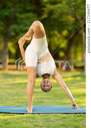 Girl enjoying outdoor yoga practice in green summer park Girl enjoying outdoor yoga practice in green summer park 117146477