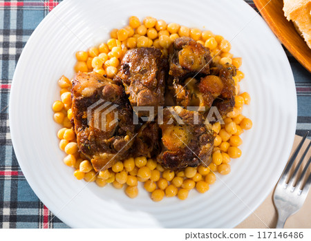 Braised oxtails with chickpeas on a white plate 117146486