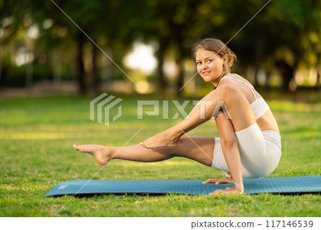 Girl in park on green grass of lawn performs Chakorasana Girl in park on green grass of lawn performs Chakorasana 117146539