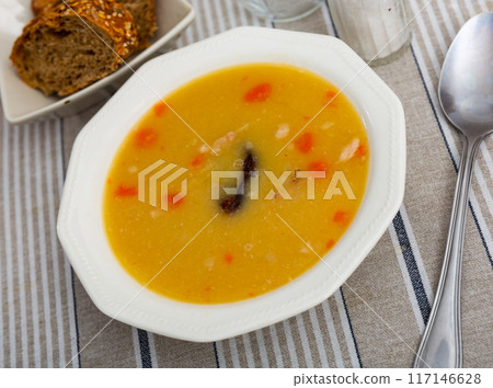 Hot pea soup with smoked meats and vegetables 117146628