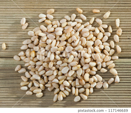 Pile of delicious pine nuts on a wooden surface Pile of delicious pine nuts on a wooden surface 117146689