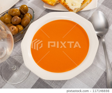 Cold soup gazpacho in bowl served with vegetables and baked breads. Spanish cuisine 117146698