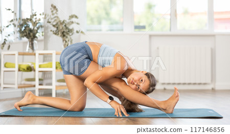 Lover of active lifestyle on yoga mat perform doing Utthan-prishthasan in gym 117146856