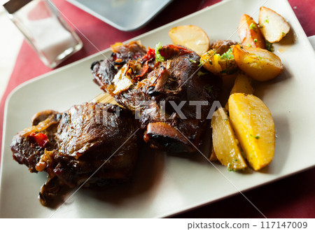 Appetizing fried pork cheeks with potatoes 117147009