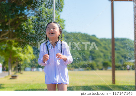 Girl taking outdoor shower at beach 117147145