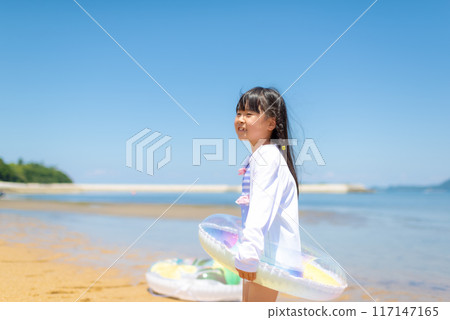 暑假期間,一個女孩在海裡游泳和玩耍 暑假期間,一個女孩在海裡游泳和玩耍 117147165