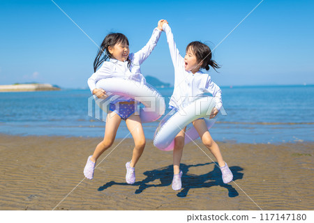 暑假期間,一個女孩在海裡游泳和玩耍 暑假期間,一個女孩在海裡游泳和玩耍 117147180