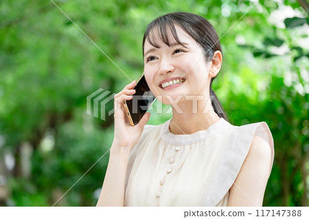 A woman who speaks with a smartphone A woman who speaks with a smartphone 117147388