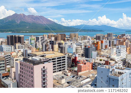 A view of Sakurajima not erupting and the city of Kagoshima. A view of the blue sky, mountains, sea and city. 117148202