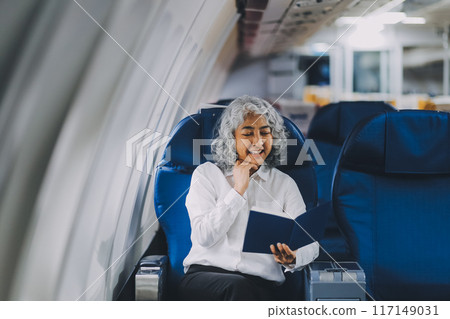 Close up hand of asian female entrepreneur working on paperwork finance report sitting near window in an airplane Close up hand of asian female entrepreneur working on paperwork finance report sitting near window in an airplane 117149031