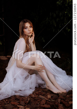Pale woman in white dress on the ground, dark mystery scene  117150043