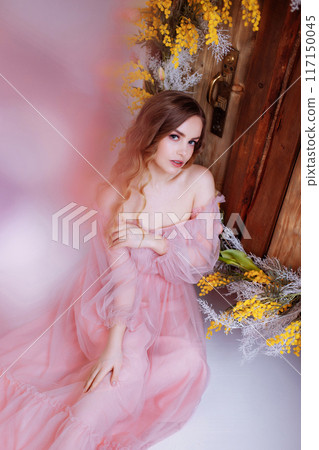 A beautiful woman in a full-length lush pink dress. 117150045
