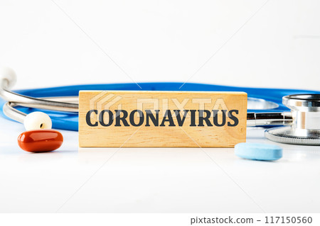 Coronavirus 2019 nCoV. New Wuhan virus. Coronavirus word written on a wooden block with a stethoscope lying next to it, pills, vitamins on a white background Coronavirus 2019 nCoV. New Wuhan virus. Coronavirus word written on a wooden block with a stethoscope lying next to it, pills, vitamins on a white background 117150560