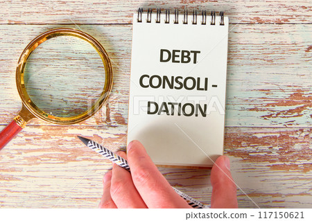 Business concept. DEBT CONSOLIDATION words in the notebook next to the magnifying glass 117150621