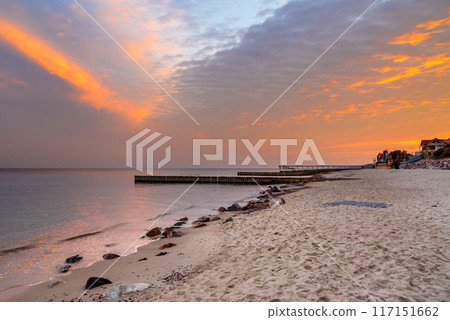 View of sand beach with wooden breakwaters on the Baltic Sea coast on sunrise in Zelenogradsk. Russia 117151662